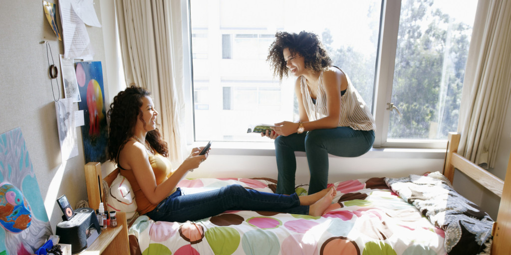 Mixed race college students relaxing in dorm